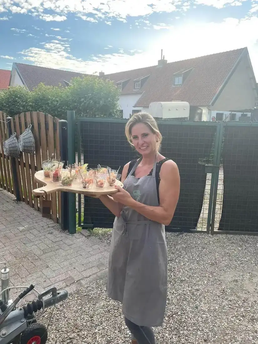 Chantal Pols met een plank vol hapjes, onderweg naar de gasten