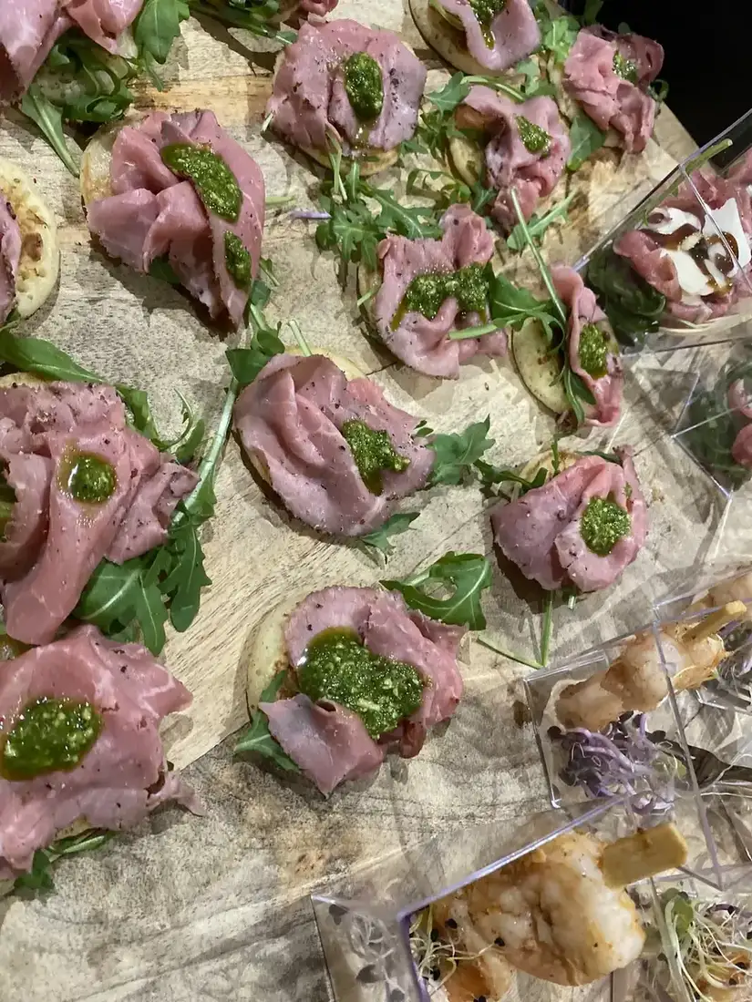 Hapjes met rosbief en pesto, opgemaakt op een plank